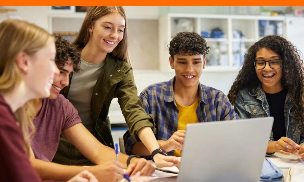 teens in a workshop working on scholarships that are hard to get, surrounded by a laptop