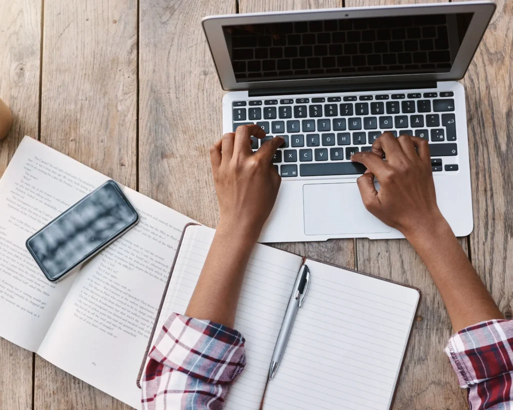 Student typing on laptop at desk