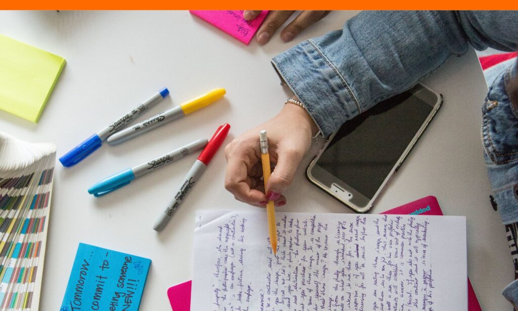 College essay planning materials including notebook with framework outline, highlighters, and laptop for how long is a common app essay