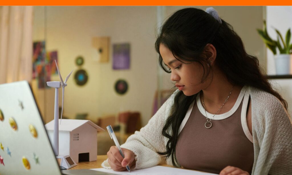High school student typing college application essay on laptop at desk for how long is a common app essay