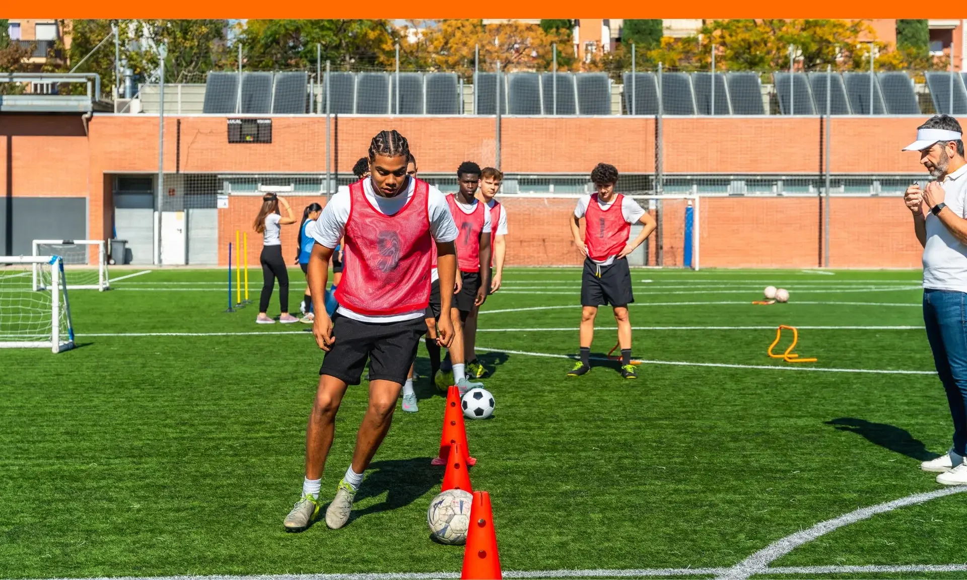 Teen boy training football at the field for extracurricular activity